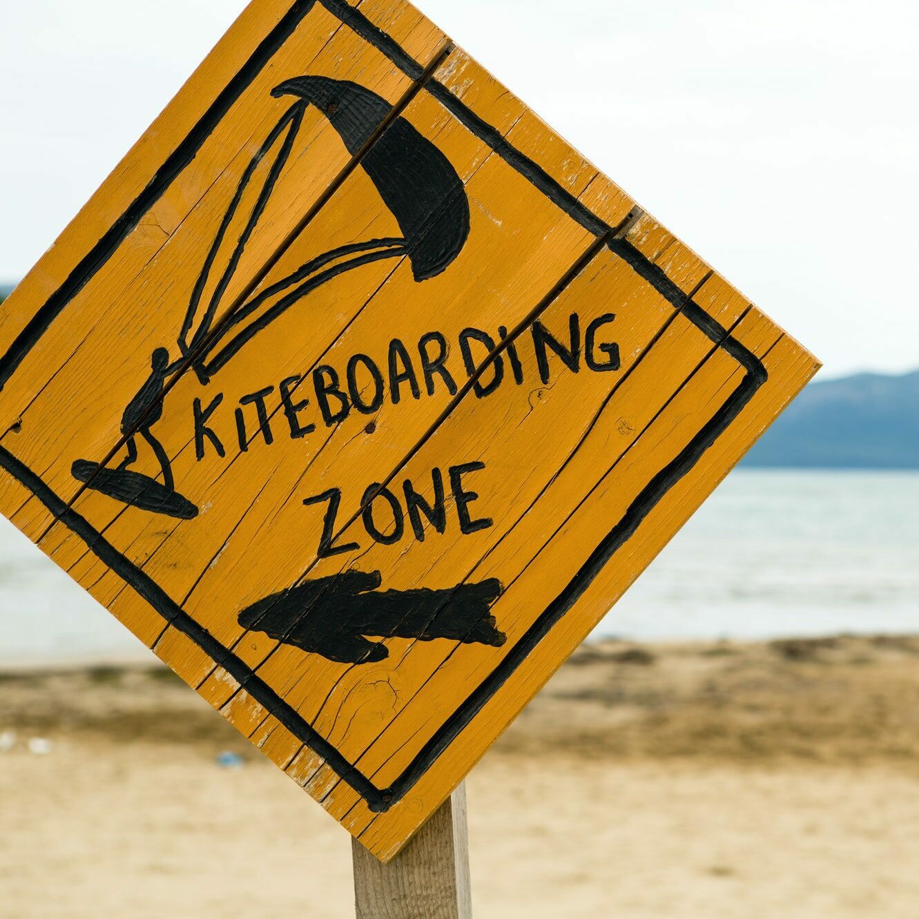 Kiteboarding, wooden kitesurfing sign on beach